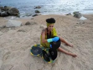 djatodocolor en la playa, lavando vinilos con cubos de colores africanos. Una escena artística junto al mar.