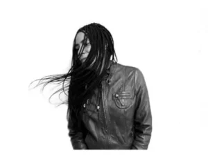 Retrato en blanco y negro de djatodocolor, DJ femenina con chaqueta de cuero y trenzas en movimiento, reflejando su energía creativa.